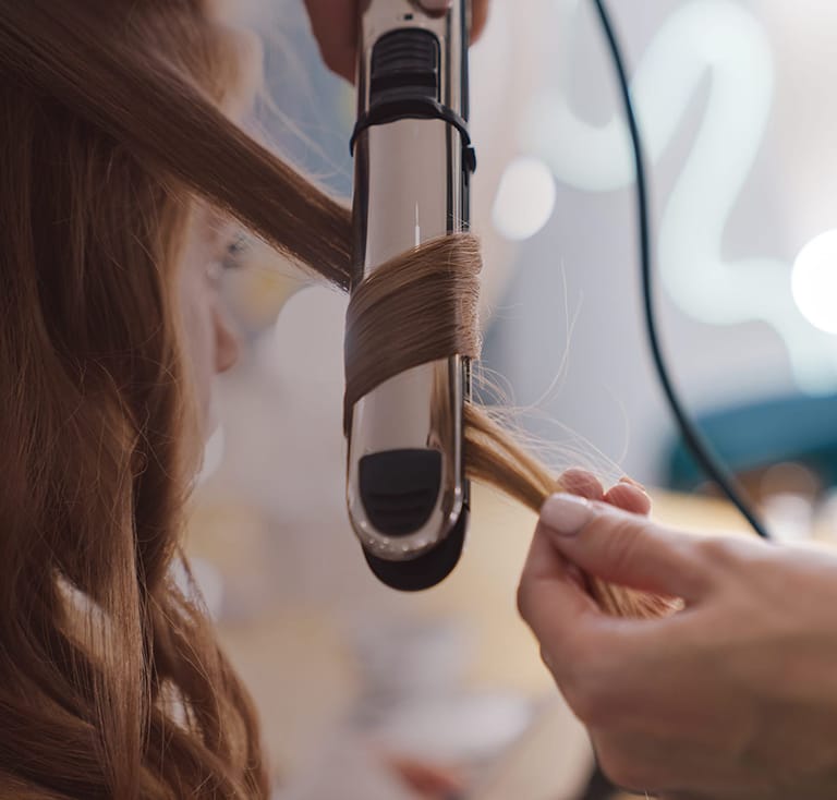 Close up of a hairdresser curling up customers hair