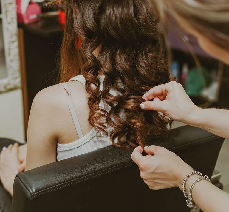 portrait of a young girl doing her hair at the hairdressers
